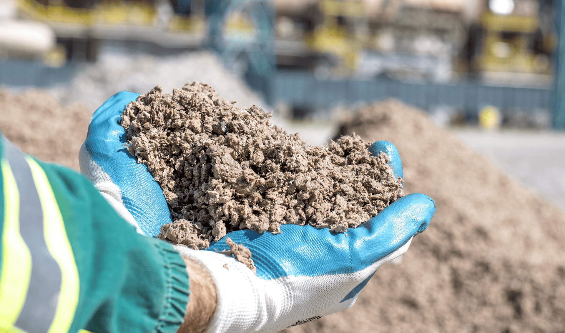 Hand holding shredded alternative fuel material, showcasing industrial innovation